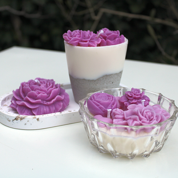 handgefertigte verzierte Kerzen mit Wachsblüten in lila